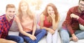 Group of cheerful friends watching videos, sitting on the couch Royalty Free Stock Photo