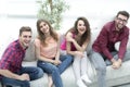 Group of cheerful friends watching videos, sitting on the couch Royalty Free Stock Photo