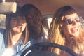 Group of cheerful happy and beautiful sunny friends young woman inside a car enjoy and have fun together traveling and driving - Royalty Free Stock Photo