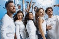 Group of cheerful joyful young people standing and celebrating together over blue background Royalty Free Stock Photo