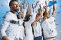 Group of cheerful joyful young people standing and celebrating together over blue background Royalty Free Stock Photo