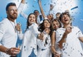 Group of cheerful joyful young people standing and celebrating together over blue background Royalty Free Stock Photo