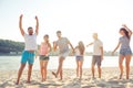 Group of cheerful people having beach party and dancing