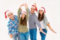 Group of cheerful posing young people in santa hats