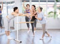 Relaxed women casually socializing at ballet barre in studio