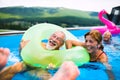 Group of cheerful seniors in swimming pool outdoors in backyard, having fun. Royalty Free Stock Photo