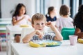 A group of cheerful small school kids in canteen, eating lunch. Royalty Free Stock Photo