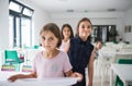 Group of cheerful small school kids with plastic trays in canteen, walking. Royalty Free Stock Photo