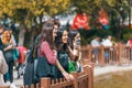 Group of cheerful teenagers looking at smart phone screen and taking photo of swans at Kugulu Park in Ankara
