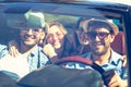 Group of cheerful young friends driving car and smiling in summer Royalty Free Stock Photo