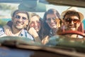 Group of cheerful young friends driving car and smiling in summer Royalty Free Stock Photo