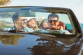 Group of cheerful young friends driving car and smiling in summer Royalty Free Stock Photo