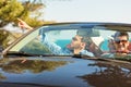 Group of cheerful young friends driving car and smiling in summer Royalty Free Stock Photo