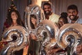 Friends holding balloons 2022 while celebrating New Year Royalty Free Stock Photo