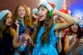 Group of cheerful young girls celebrating Christmas. Headphones Royalty Free Stock Photo