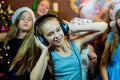 Group of cheerful young girls celebrating Christmas. Headphones Royalty Free Stock Photo