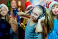 Group of cheerful young girls celebrating Christmas. Headphones Royalty Free Stock Photo