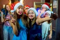 Group of cheerful young girls celebrating Christmas. Selfie Royalty Free Stock Photo