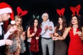 Group of cheerful young people carrying sparklers and champagne flutes dancing in new year party and looking happy. Royalty Free Stock Photo