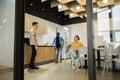 Group of cheerful young people talking and smiling during coffee break time in the office. Team of professional software Royalty Free Stock Photo