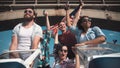 Group of cheering laughing friends on a speedboat