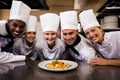 Group of chefs looking at prepared pasta in kitchen Royalty Free Stock Photo