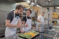 Group of chefs prepare fresh food in a modern kitchen while communicating with each other