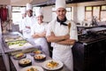 Group of chefs standing with arms crossed in kitchen