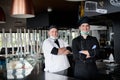 Group chefs standing together in the kitchen at restaurant wearing protective medical mask and gloves in coronavirus new normal