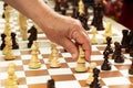 Group of chess pieces on the portable board.Man moving figure,closeup photography.Playing in the park concept.Family rest or Royalty Free Stock Photo