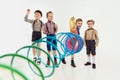 Group of childen, boys in classical retro clothes playing with slinky toy over grey studio background. Concept of game