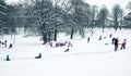 Group of children and adult playing on snow in winter time Royalty Free Stock Photo