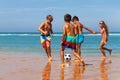 Children play soccer on the sand beach near water Royalty Free Stock Photo