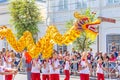 A group of children carry on their hands the construction of a toy of a large dragon at the procession `Festival of Flowers