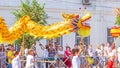 A group of children carry on their hands the construction of a toy of a large dragon at the procession `Festival of Flowers