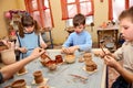 Group of children decorating their clay pottery Royalty Free Stock Photo