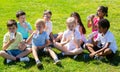 Group of children drink water from bottles on the summer lawn