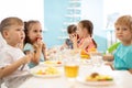 Group of children eating from plates in daycare centre Royalty Free Stock Photo