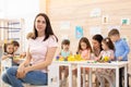 Group of kids and educator doing handcrafting together in classroom in kindergarten Royalty Free Stock Photo