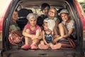 Group of children in family car trunk luggage going to road trip in family car symbolizing kids togetherness friendship and happy Royalty Free Stock Photo