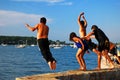 A group of children have fun jumping into the water on a summerÃ¢â¬â¢s day
