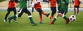 Group of children ikicking soccer ball. Kids in two football teams running after classic soccer ball. Horizntal sports background Royalty Free Stock Photo