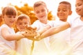 Group of children joining hands in park on sunny day Royalty Free Stock Photo