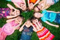 A group of children lying on the green grass in the Park. The interaction of the children. Royalty Free Stock Photo