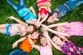 A group of children lying on the green grass in the Park. The interaction of the children. Royalty Free Stock Photo