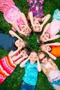 A group of children lying on the green grass in the Park. The interaction of the children. Royalty Free Stock Photo