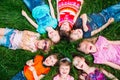 A group of children lying on the green grass in the Park. The interaction of the children. Royalty Free Stock Photo