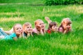 A group of children lying on the green grass in the Park. The interaction of the children. Royalty Free Stock Photo