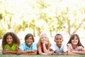 Group Of Children Lying On Stomachs In Park