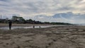Children Playing on a Beach with Structures and Cloudy Skies Royalty Free Stock Photo